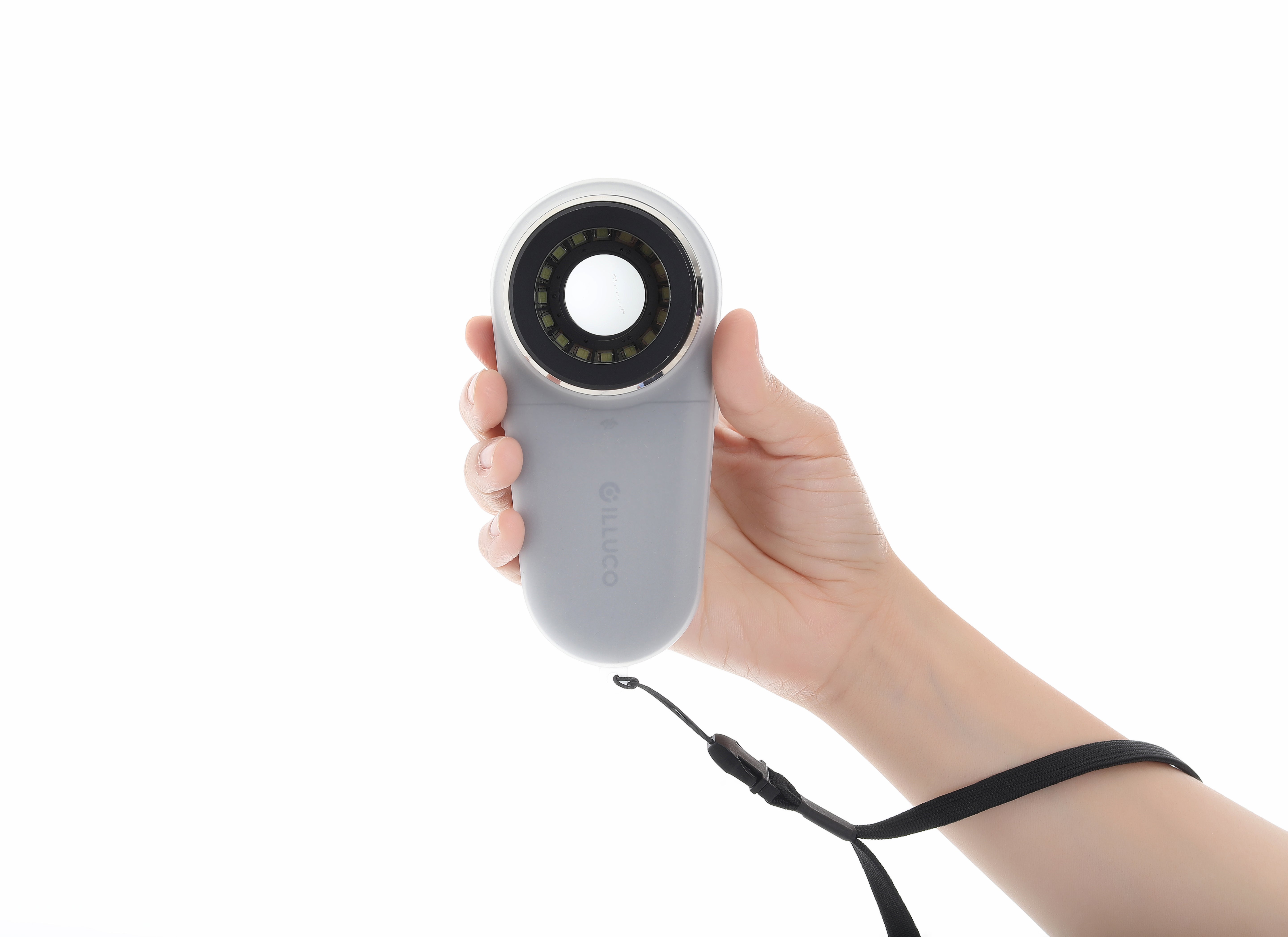 Hand holding a gray handheld device with a black cord on a white background